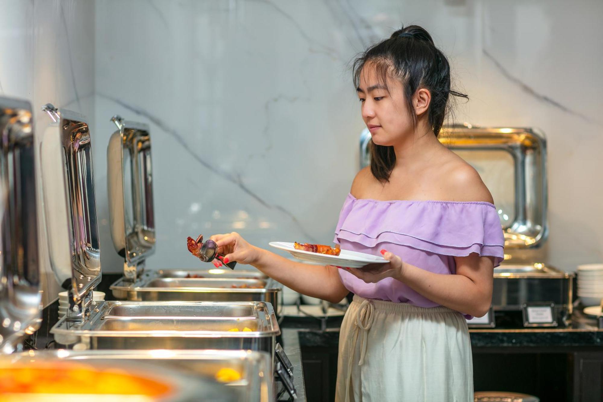 May De Ville Lakeside Hotel Hanoi Exteriör bild A woman serving herself at a buffet